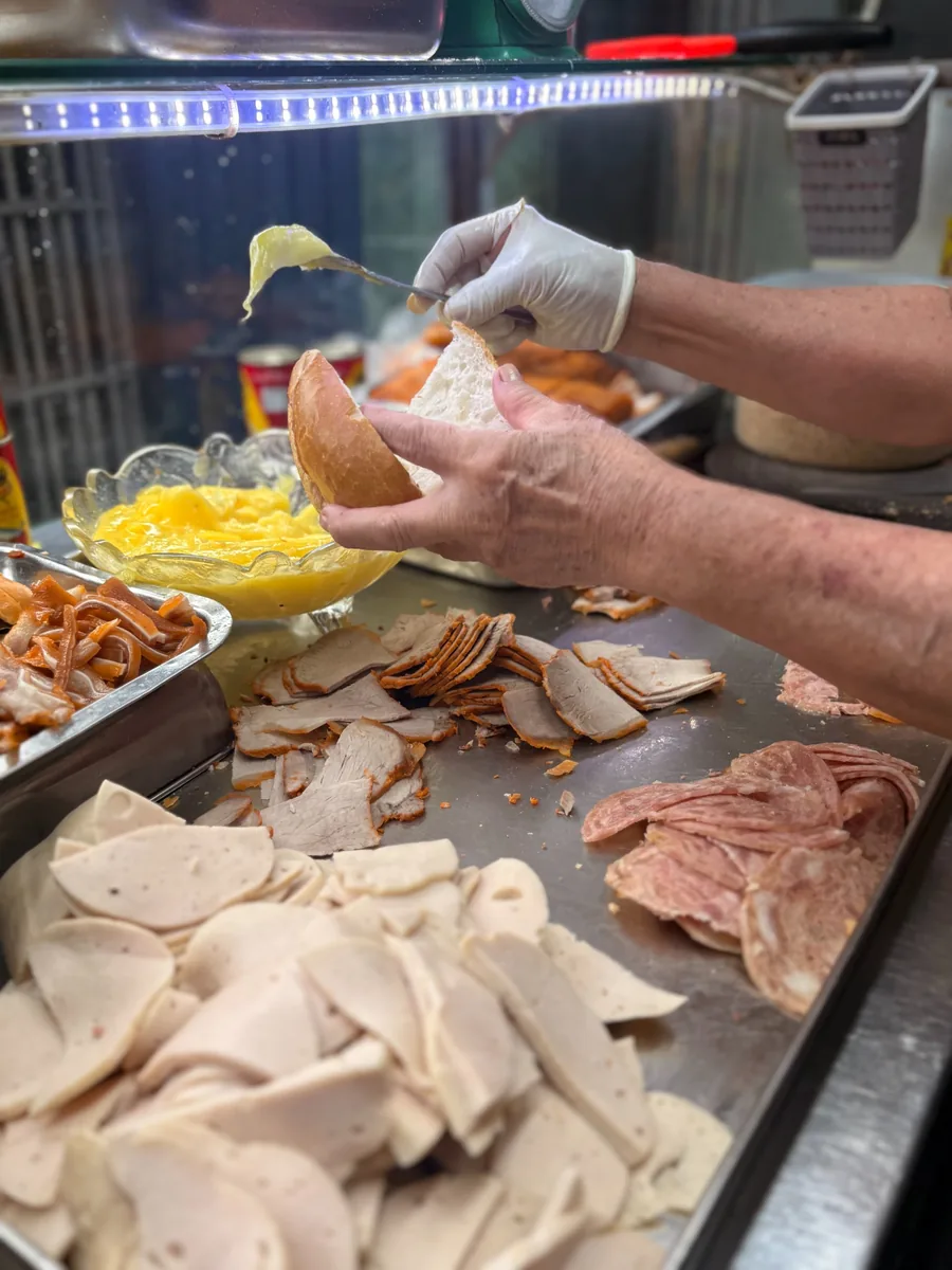 A local vendor preparing bánh mì at a Saigon street-food stall