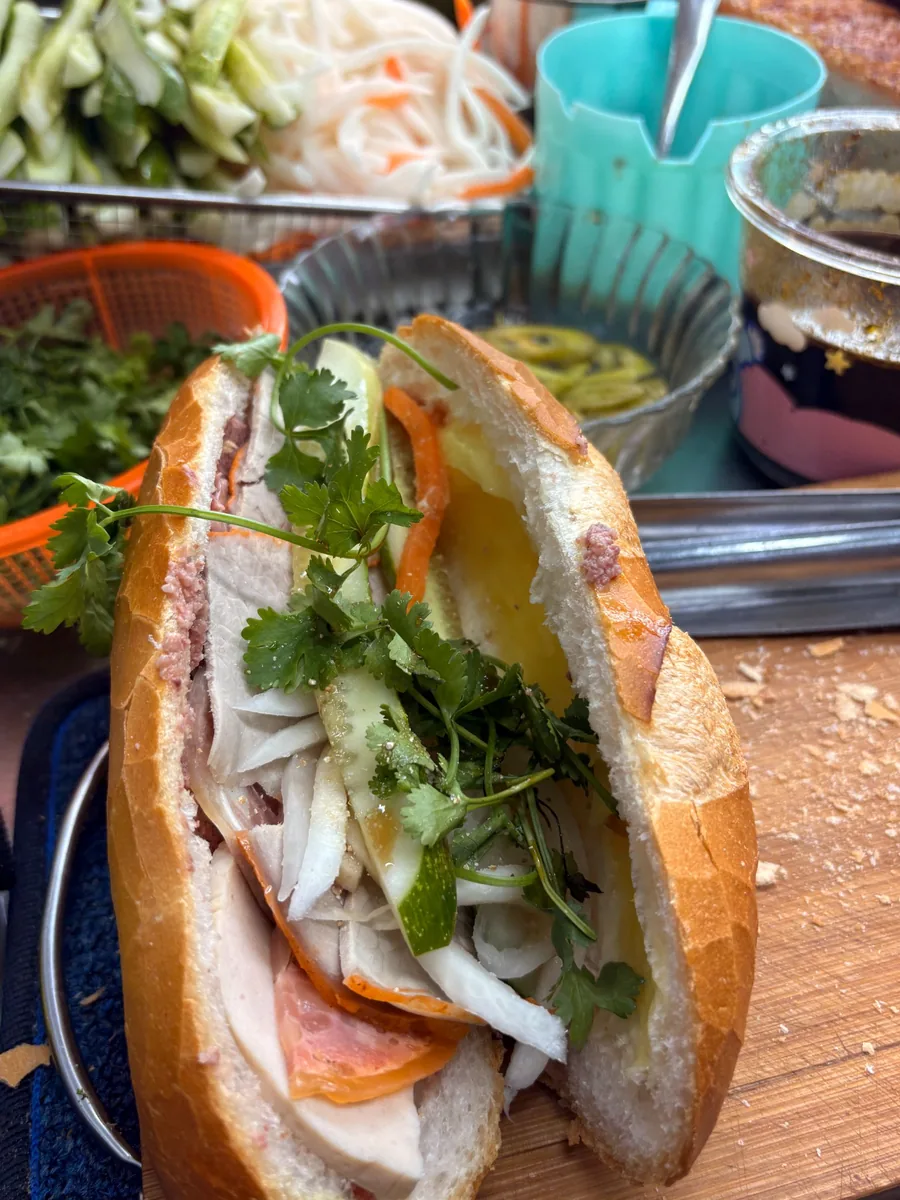 Fresh bánh mì with herbs and pickles at a local Saigon stall