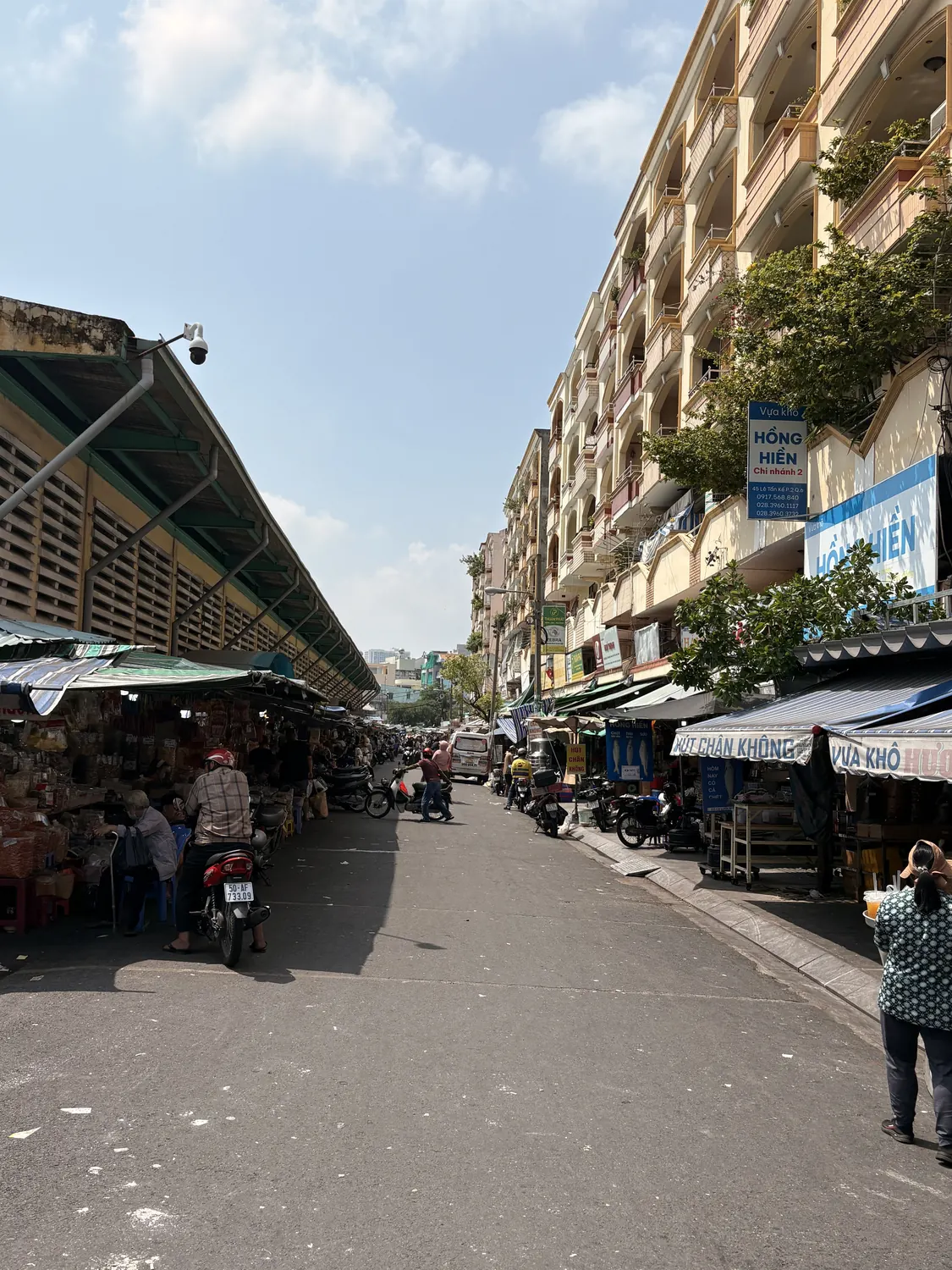 Market street in Chợ Lớn with local shops and motorbikes