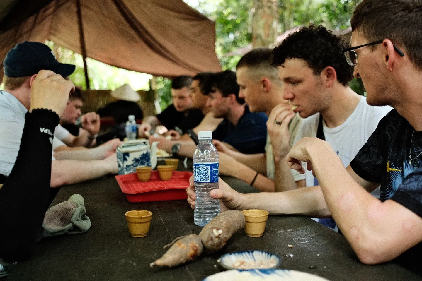 Guests sitting around cassava and tea during a break at the Cu Chi Tunnels