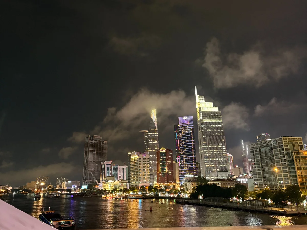 Central Saigon skyline glowing across the river at night from the old District 4 area
