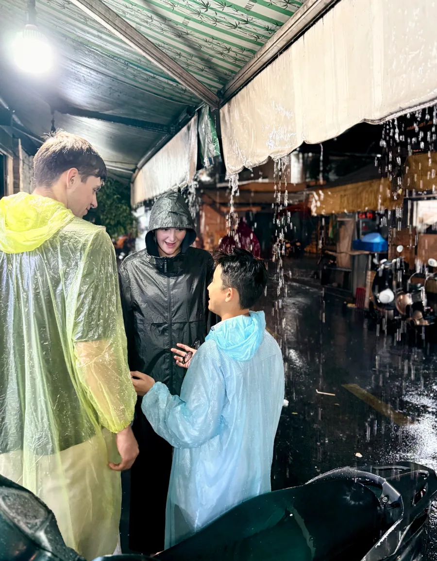 OG Saigon guests and local hosts sheltering from heavy rain during a food tour