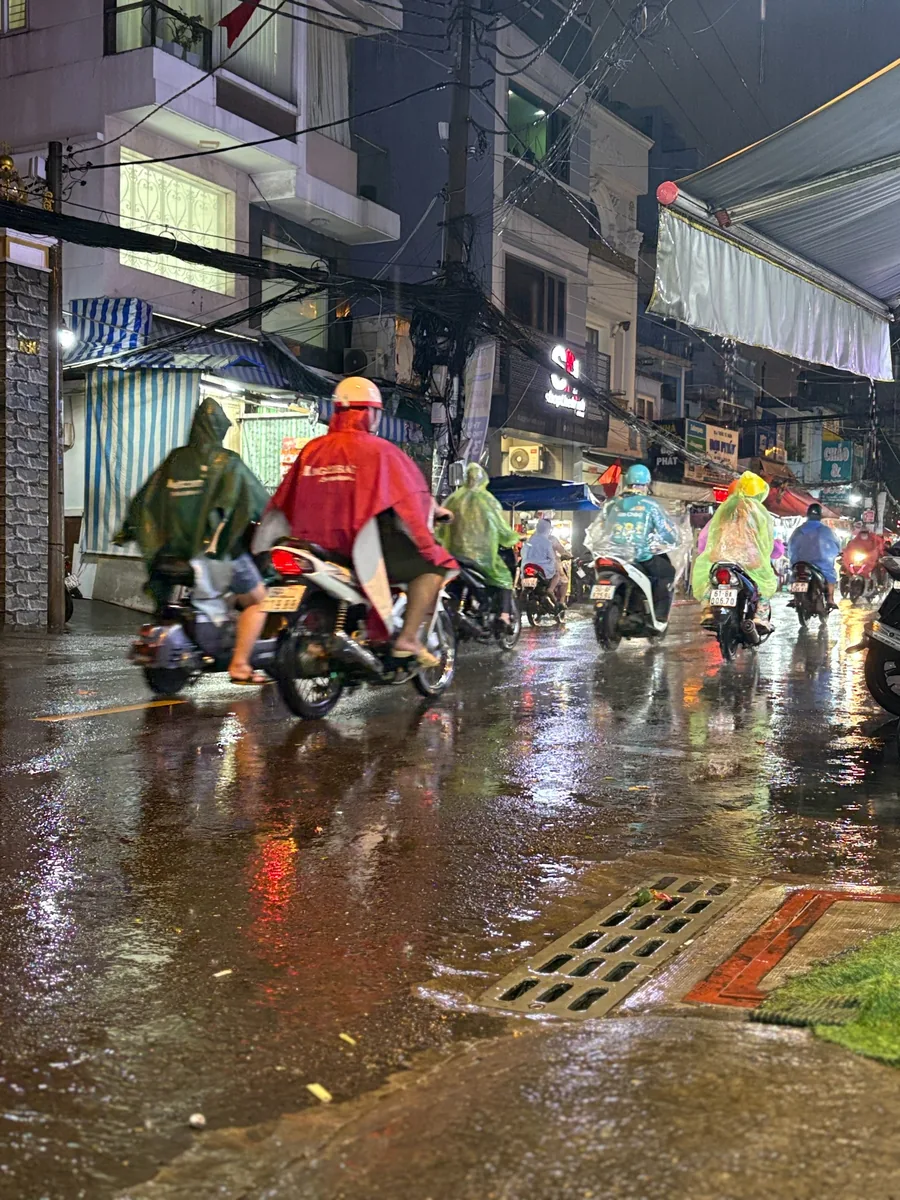 Motorbikes moving through Saigon during an evening rain shower