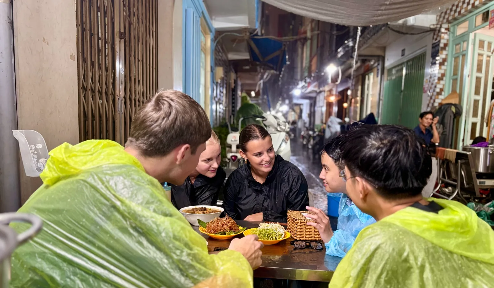 Guests sharing local food with OG Saigon in a neighborhood alley